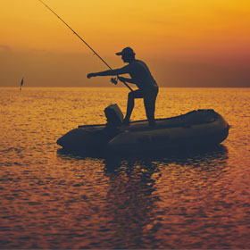 Angler fishing at sunset during best times to fish