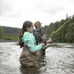 Young girl and her father fly fishing