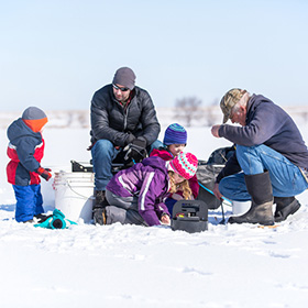 A family ice fishing with young kids