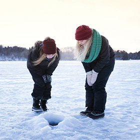 Two women ice fishing
